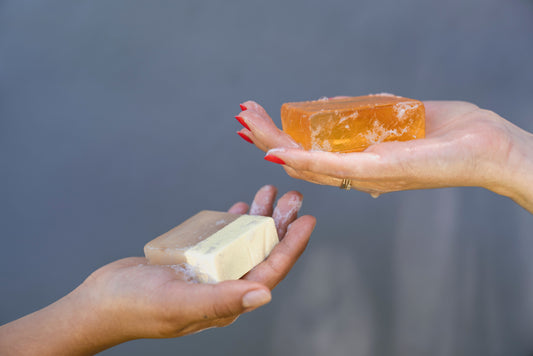 Two hands holding natural soap bars close together